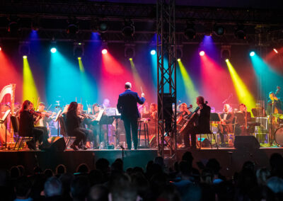 Irish Philharmonic Orchestra on stage with colourful lighting
